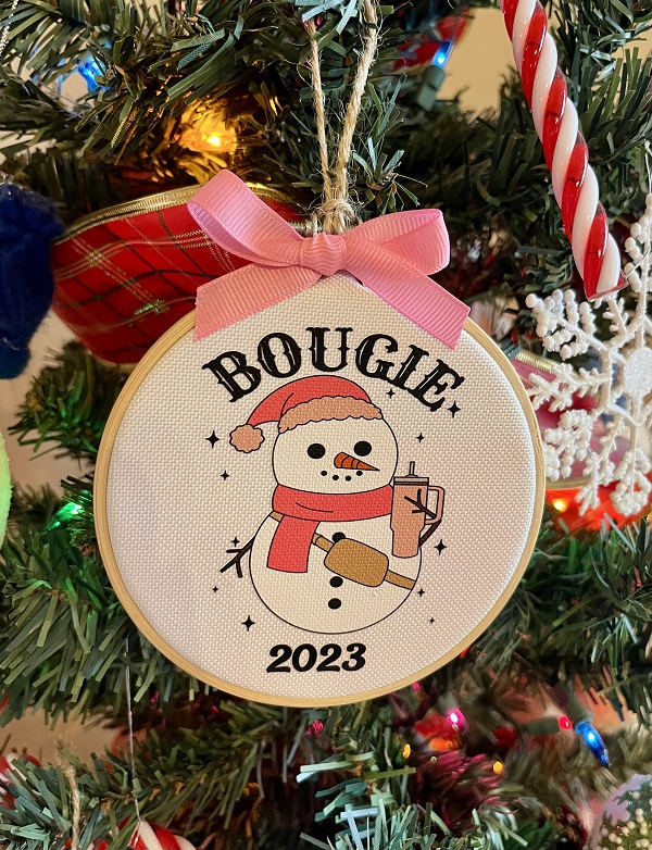 Bougie Snowgirl Ornament-4 inch wood hoop with design dtf on to durable canvas fabric finished with a pink grosgrain ribbon
